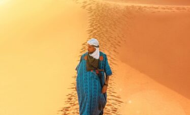 Lone figure walking during desert sunset