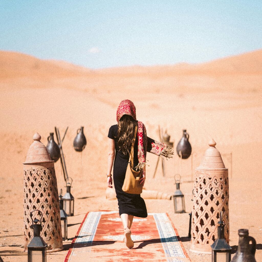 Woman walking with camels in the Sahara