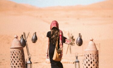 Woman walking with camels in the Sahara