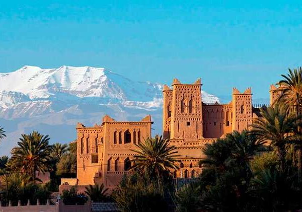 Snow-capped mountains behind a Moroccan kasbah