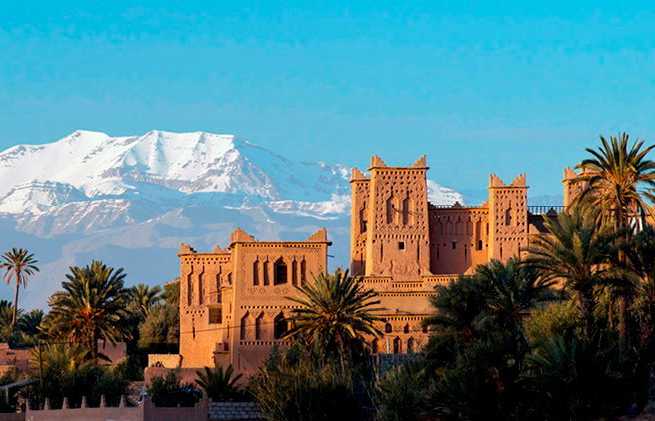 Snow-capped mountains behind a Moroccan kasbah