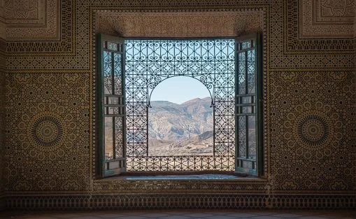 Ornate window overlooking Moroccan hills