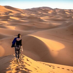 woman walking on desert during daytime morocco travel