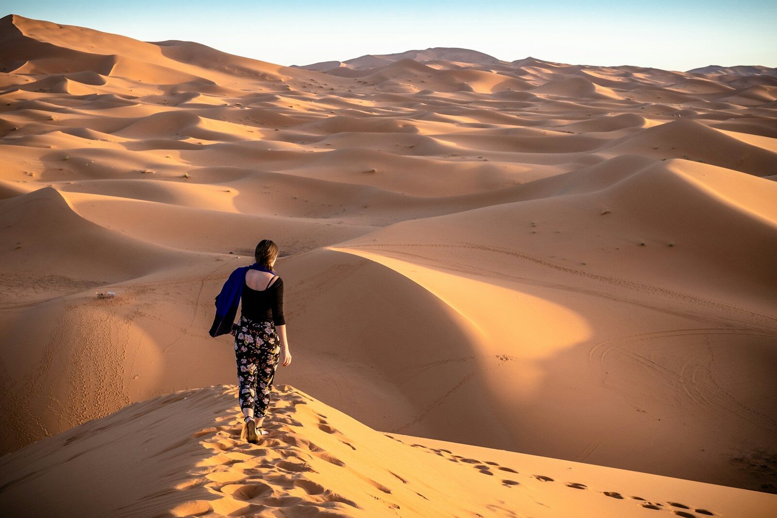 woman walking on desert during daytime morocco travel
