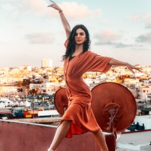 Concerts Morocco a woman standing on a ledge with her arms outstretched