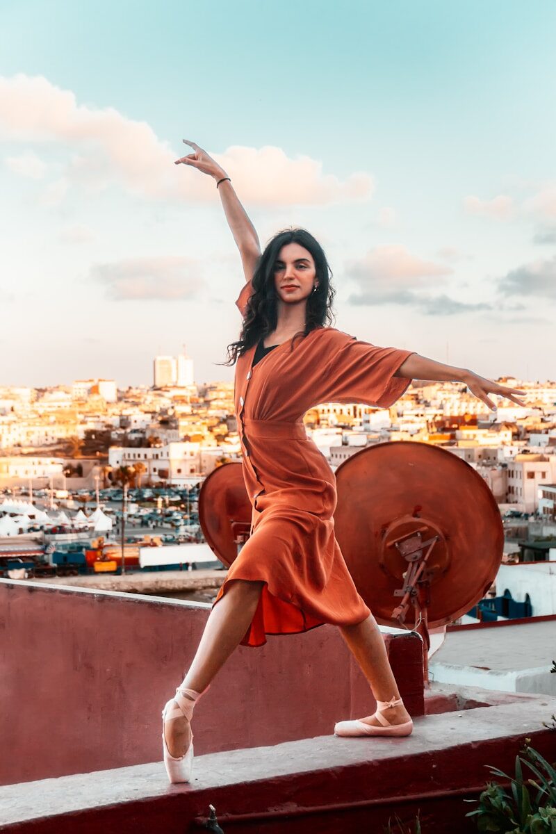 Concerts Morocco a woman standing on a ledge with her arms outstretched
