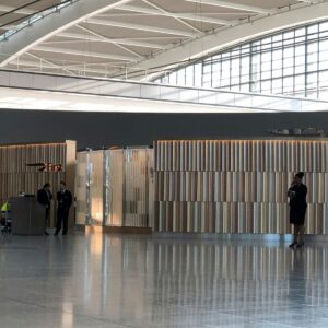 VIP Airport man in black shirt walking on white floor tiles