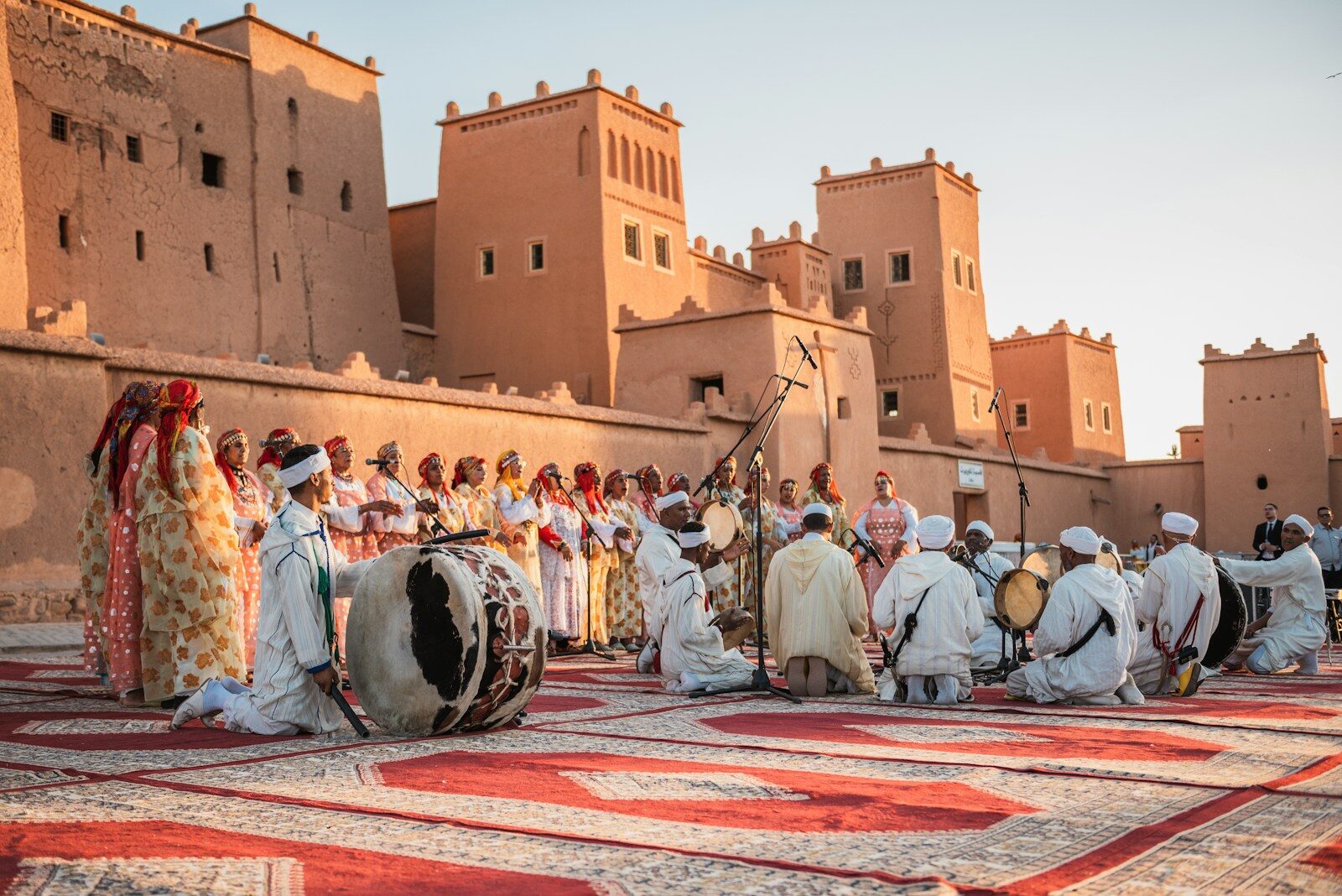 FOLKLORE a group of people standing on top of a rug