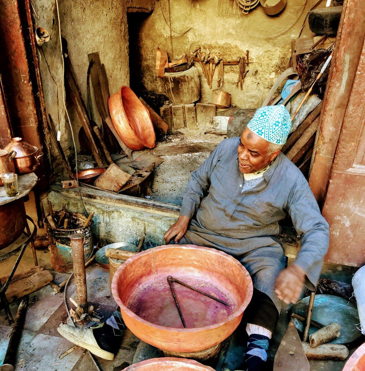 Heritage a man sitting in a room filled with pots and pans