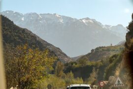 Travel in Morocco A car drives through mountains on a sunny day.