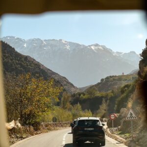 Travel in Morocco A car drives through mountains on a sunny day.