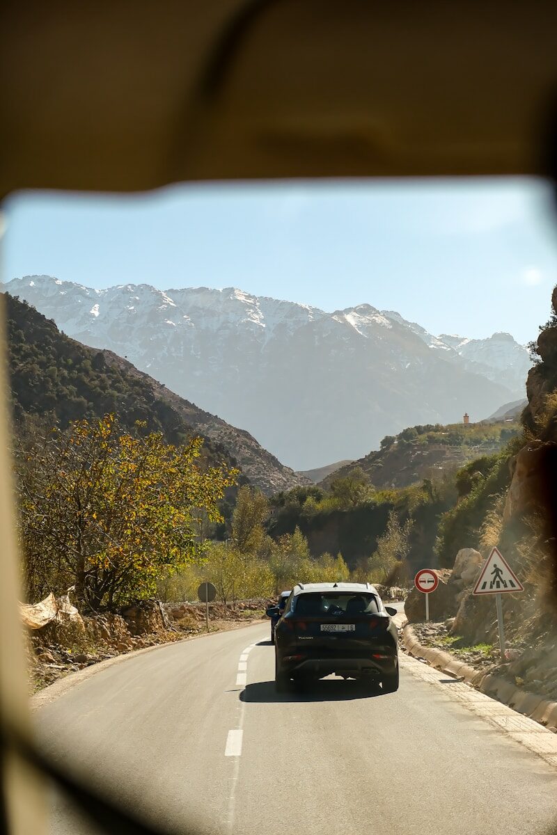 Travel in Morocco A car drives through mountains on a sunny day.