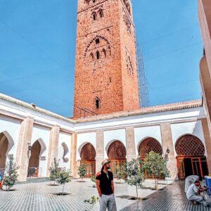 Retirement in Morocco Man standing in courtyard of koutoubia mosque, marrakesh.