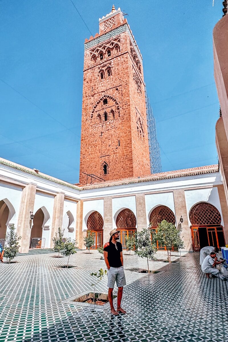 Retirement in Morocco Man standing in courtyard of koutoubia mosque, marrakesh.