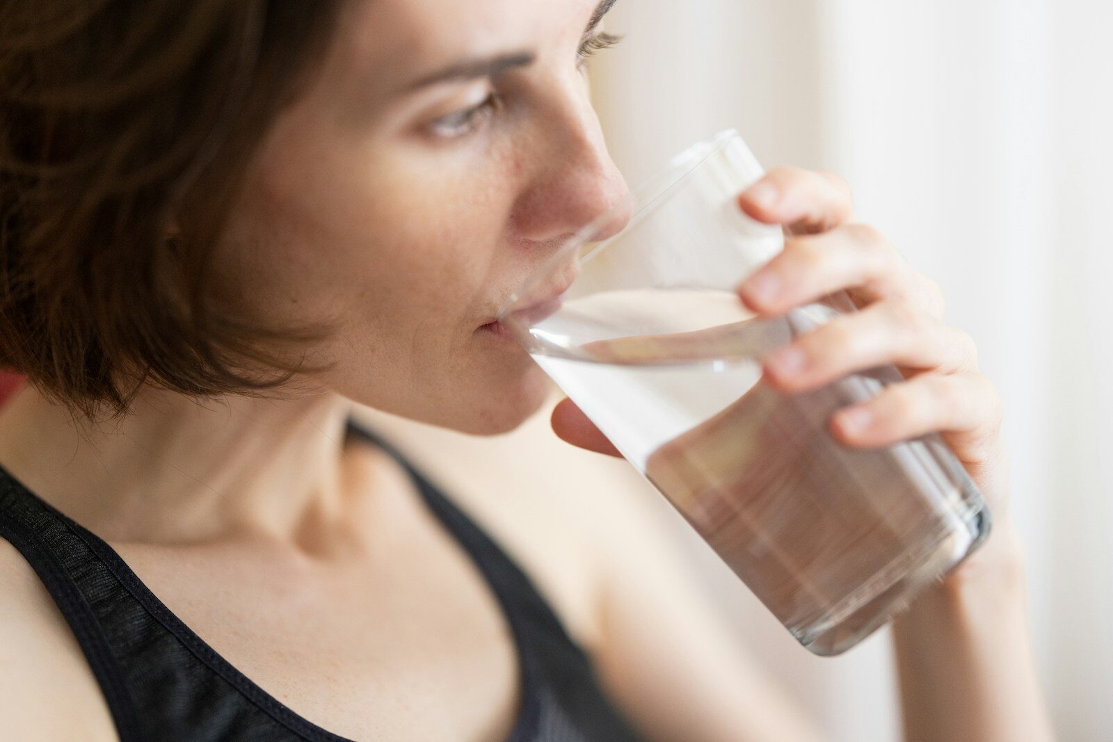 Drinking Water woman in black tank top drinking water