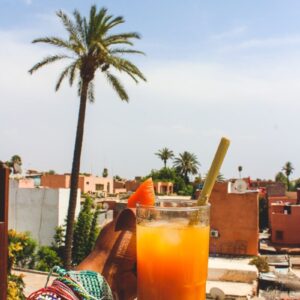 Morocco Tourism person holding clear glass mug with orange liquid