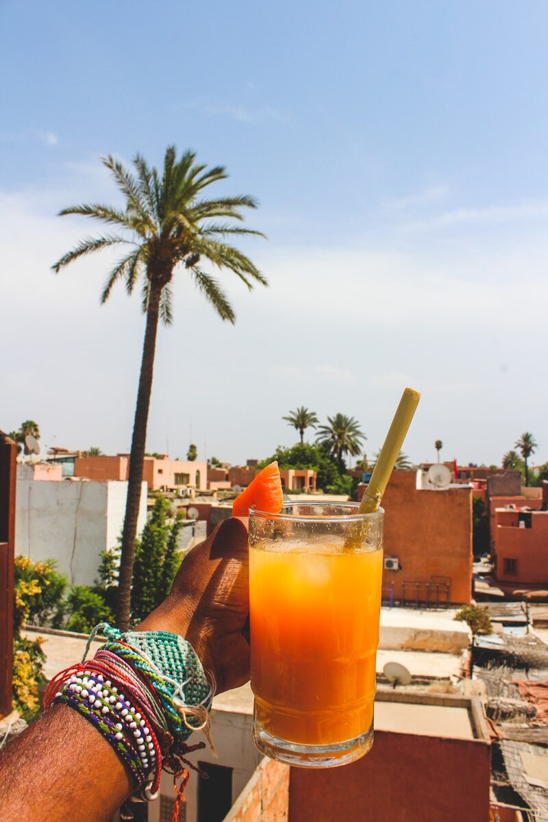 Morocco Tourism person holding clear glass mug with orange liquid