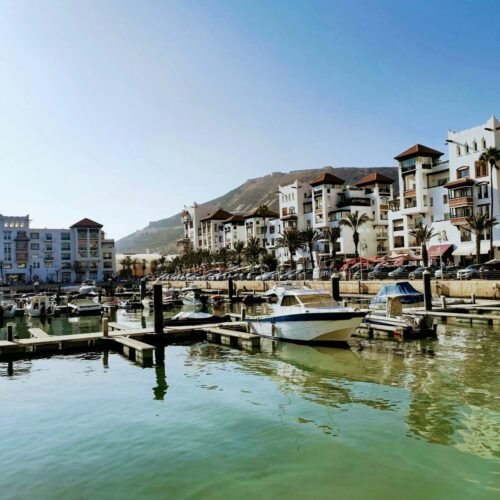 white boat on dock near buildings during daytime