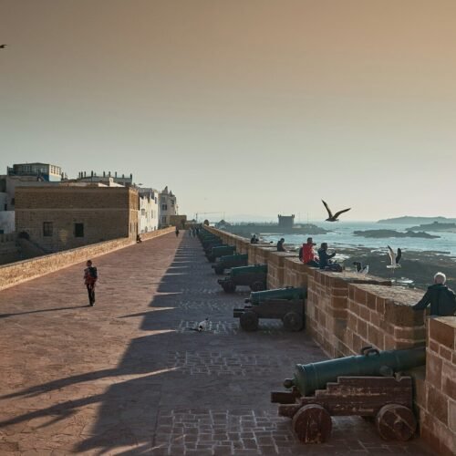 A long wall overlooks the ocean and the city.