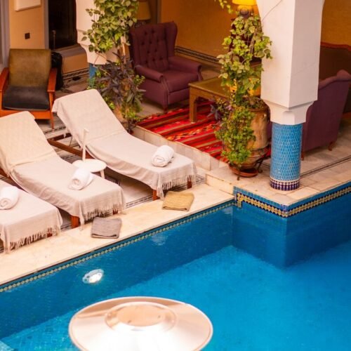 a large swimming pool with lounge chairs around it