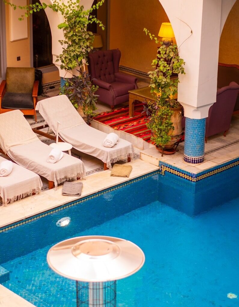 a large swimming pool with lounge chairs around it