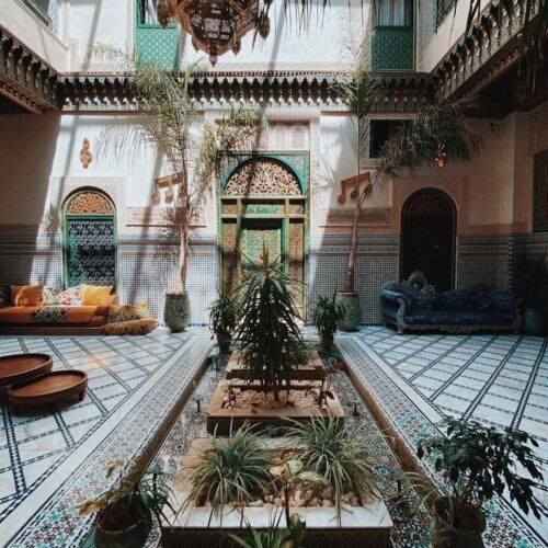 a courtyard with a fountain surrounded by potted plants