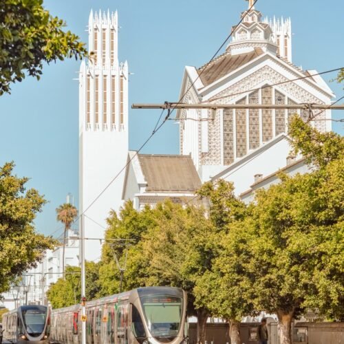 a train on the tracks in front of a church