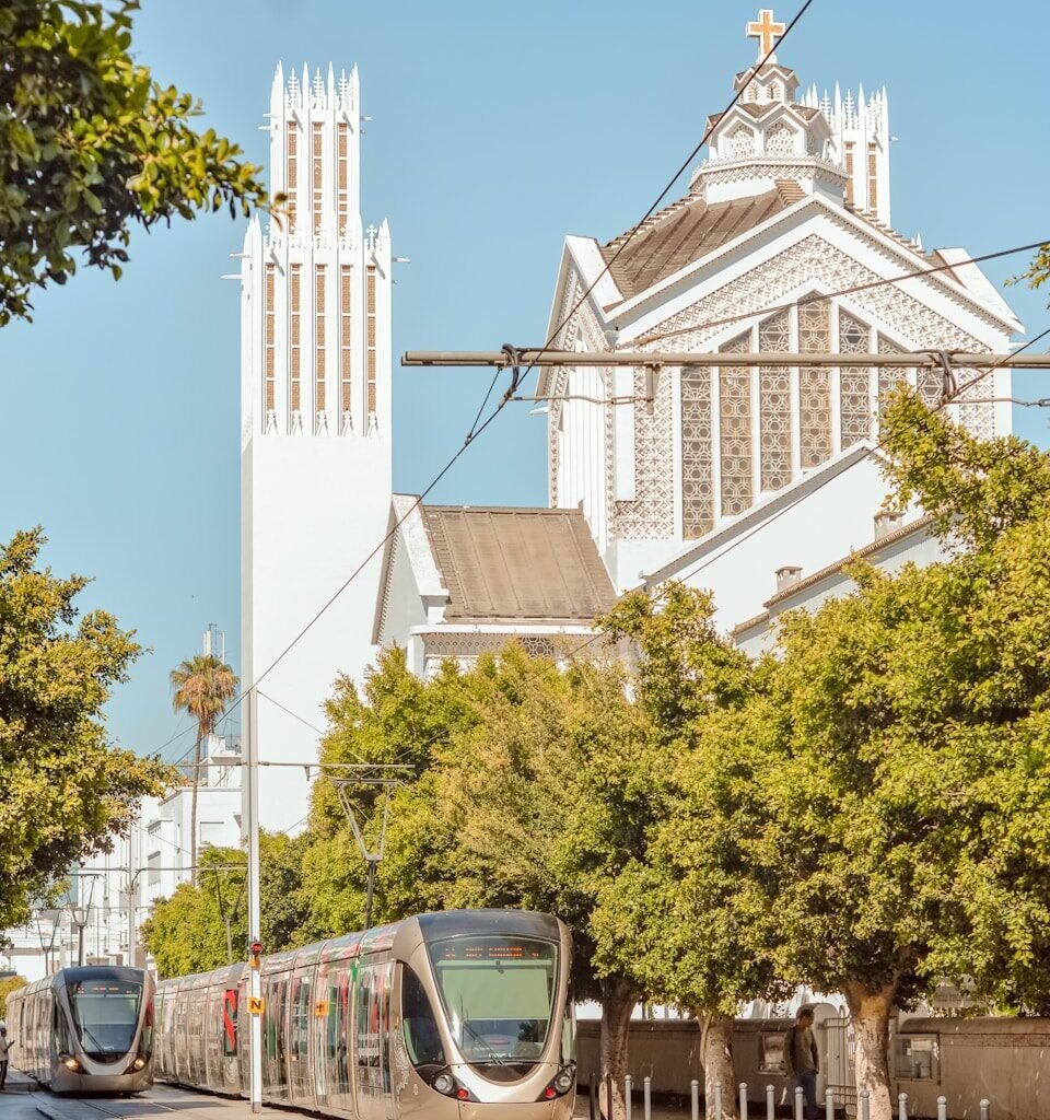 a train on the tracks in front of a church