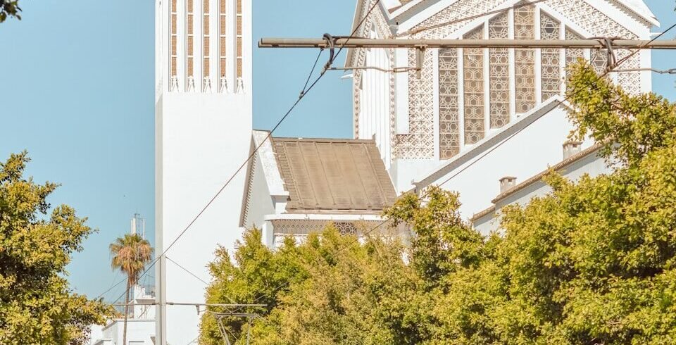 a train on the tracks in front of a church
