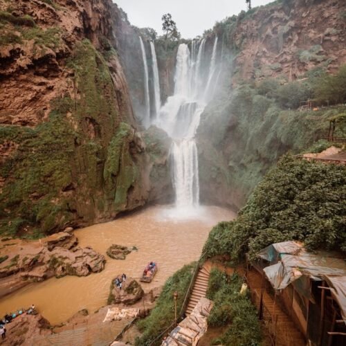 a group of people standing in front of a waterfall