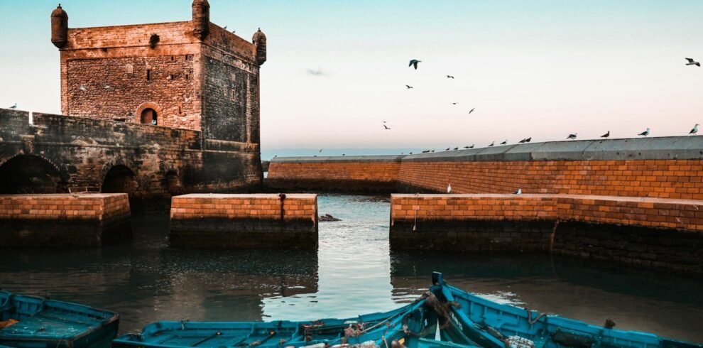 brown brick building near body of water during daytime