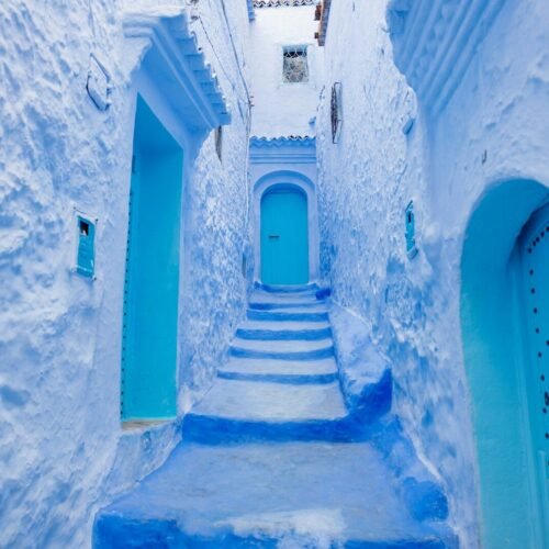 a narrow alley way with blue painted steps