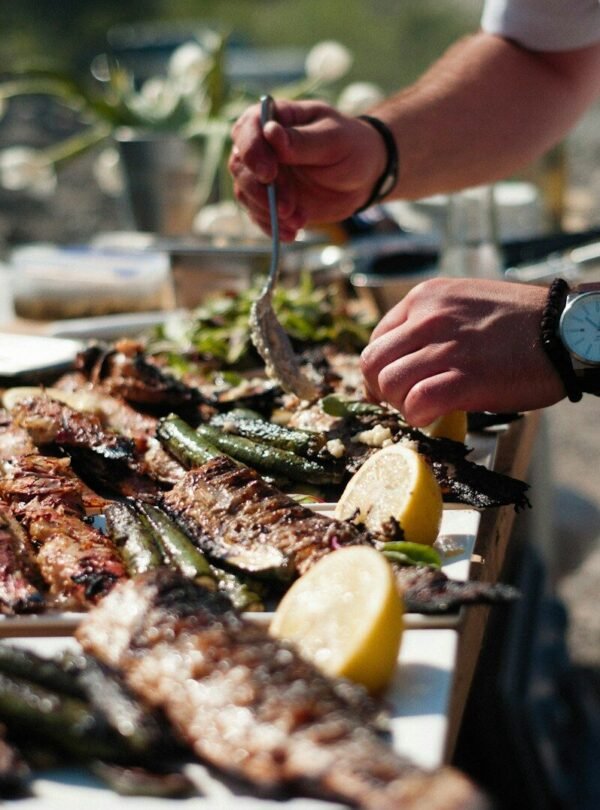 a person holding a fork over a table of seafood