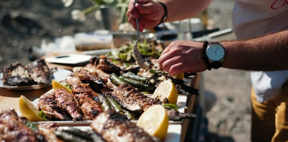 a person holding a fork over a table of seafood