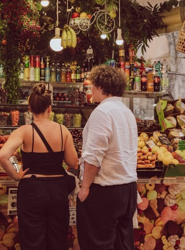 People browsing a vibrant fruit and vegetable market stall.
