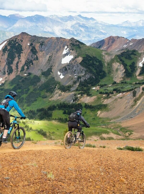 man in blue jacket riding bicycle on dirt road during daytime