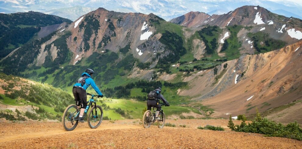 man in blue jacket riding bicycle on dirt road during daytime