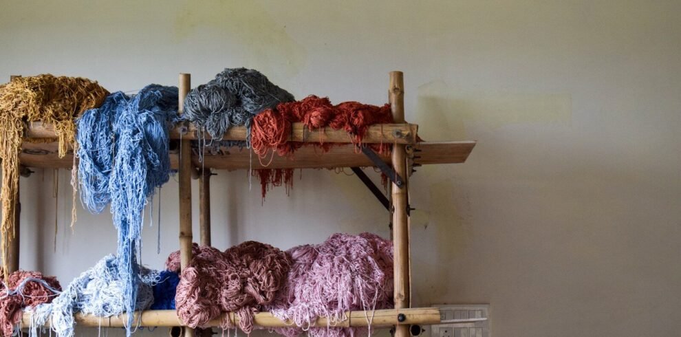 Bunches of colorful yarn on a wooden shelf