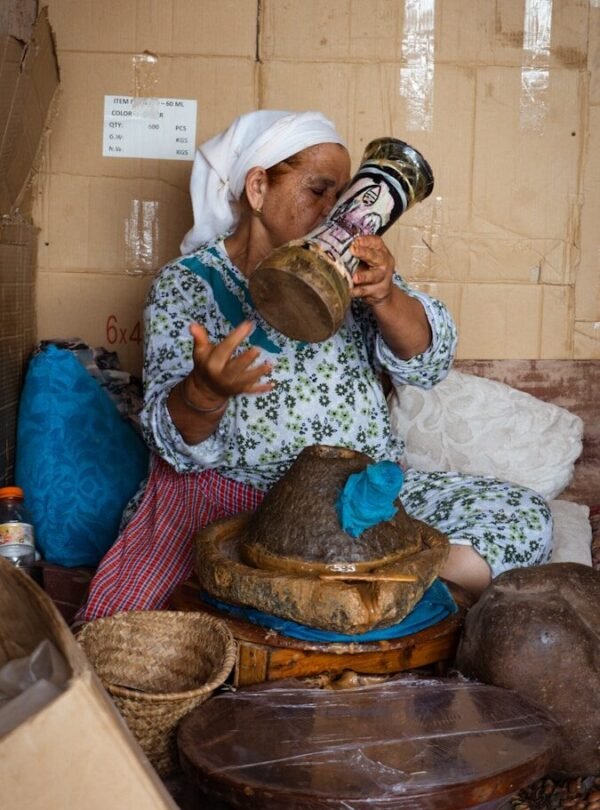 Woman in headscarf holding decorated vase toasting tool