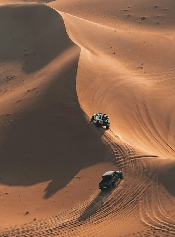 Two atvs driving on sand dunes