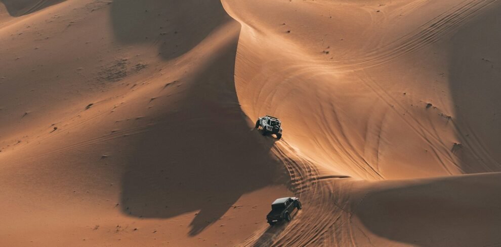 Two atvs driving on sand dunes