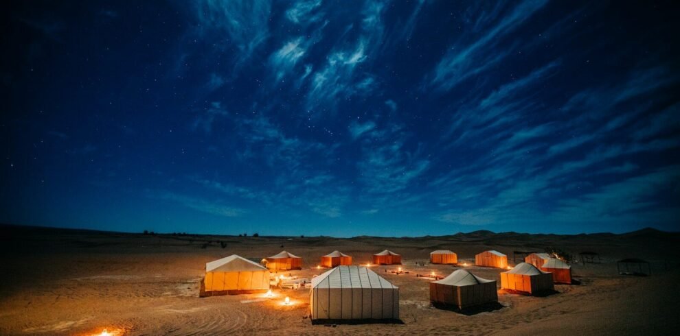 white and brown tent on brown field under blue sky during night time