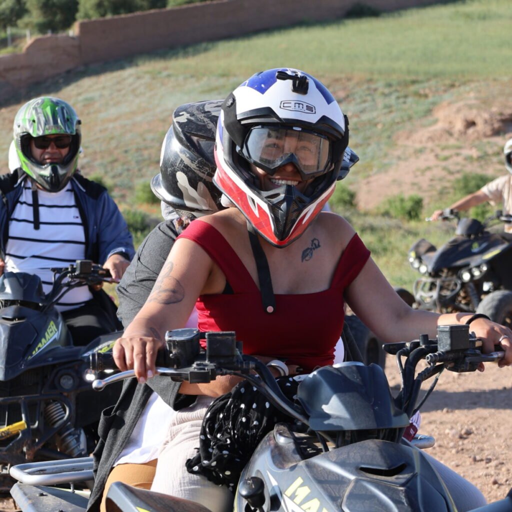 Close-up of participants wearing protective helmets while driving quad bikes on a dirt path