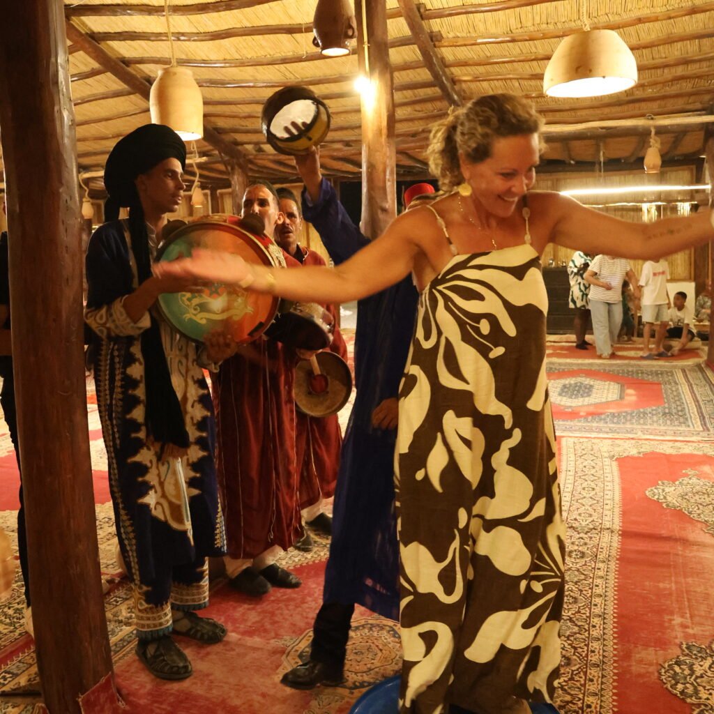 Traveler participating in a traditional dance performance with local musicians in a rustic venue