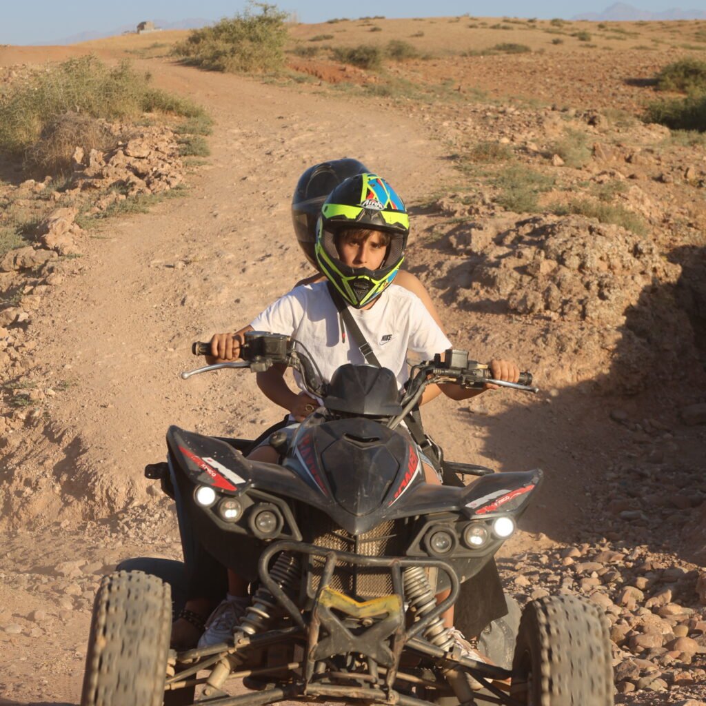 Rider steering a quad bike along a winding off-road track during an excursion