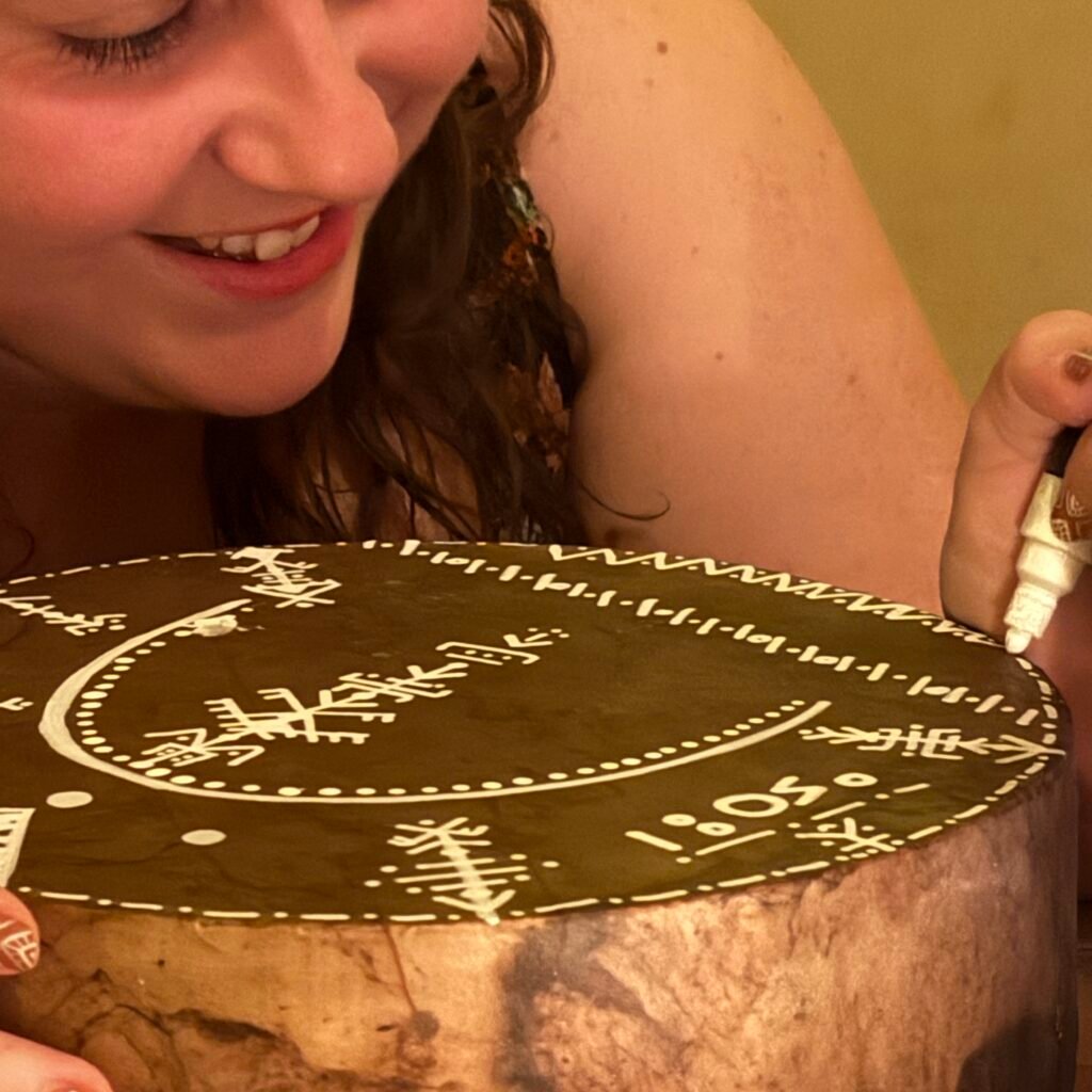 Woman painting symbols on drum