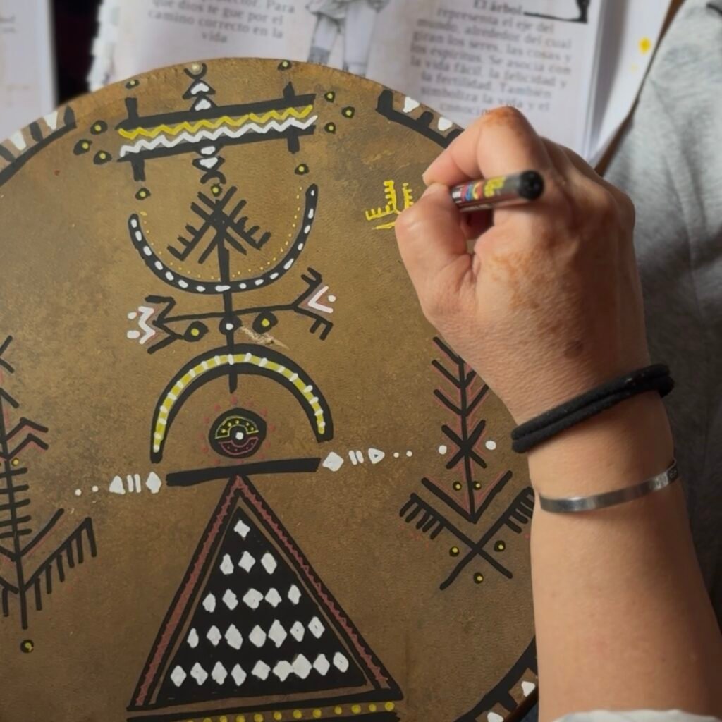 Hand painting symbols on drum