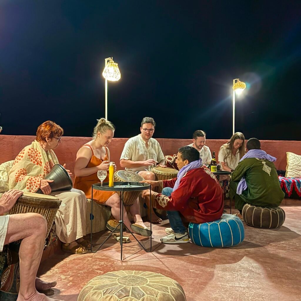 Group of travelers participating in an evening music performance and drum session in Morocco