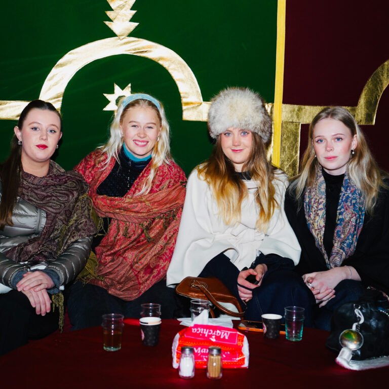 Group of female tourists enjoying traditional tea inside a decorated Moroccan Berber tent