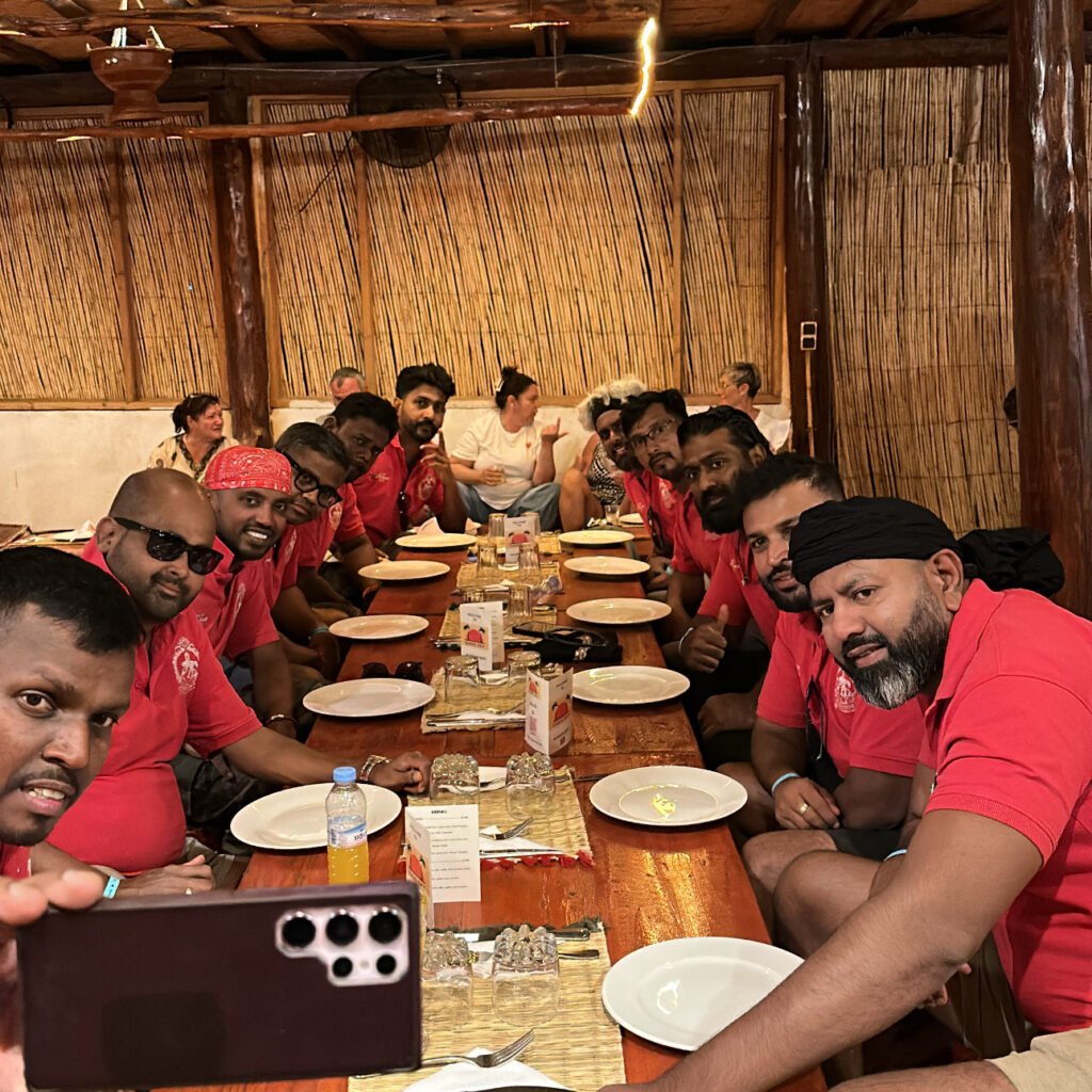 Group of friends posing for a selfie around a long wooden dining table inside a rustic restaurant